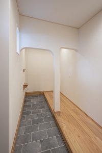 開放的な玄関は、空間の印象が間延びしないように下がり壁を施工。